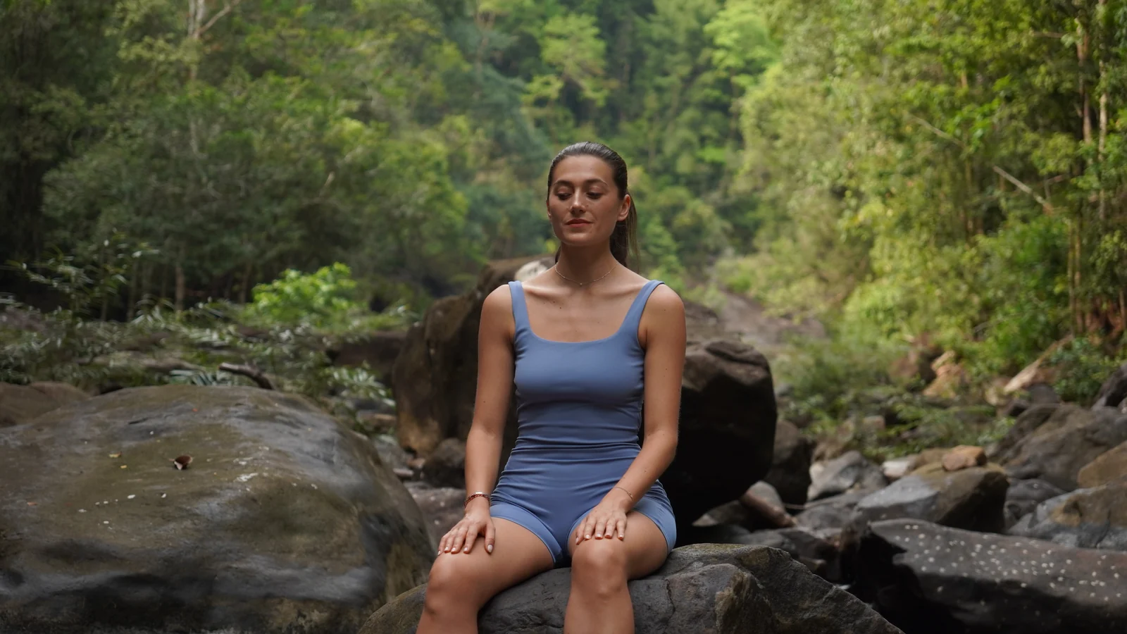 A model seated calmly with her eyes closed